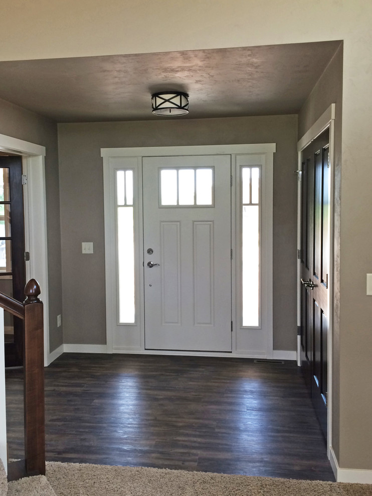 Inspiration for a mid-sized craftsman vinyl floor entryway remodel in Milwaukee with beige walls and a white front door