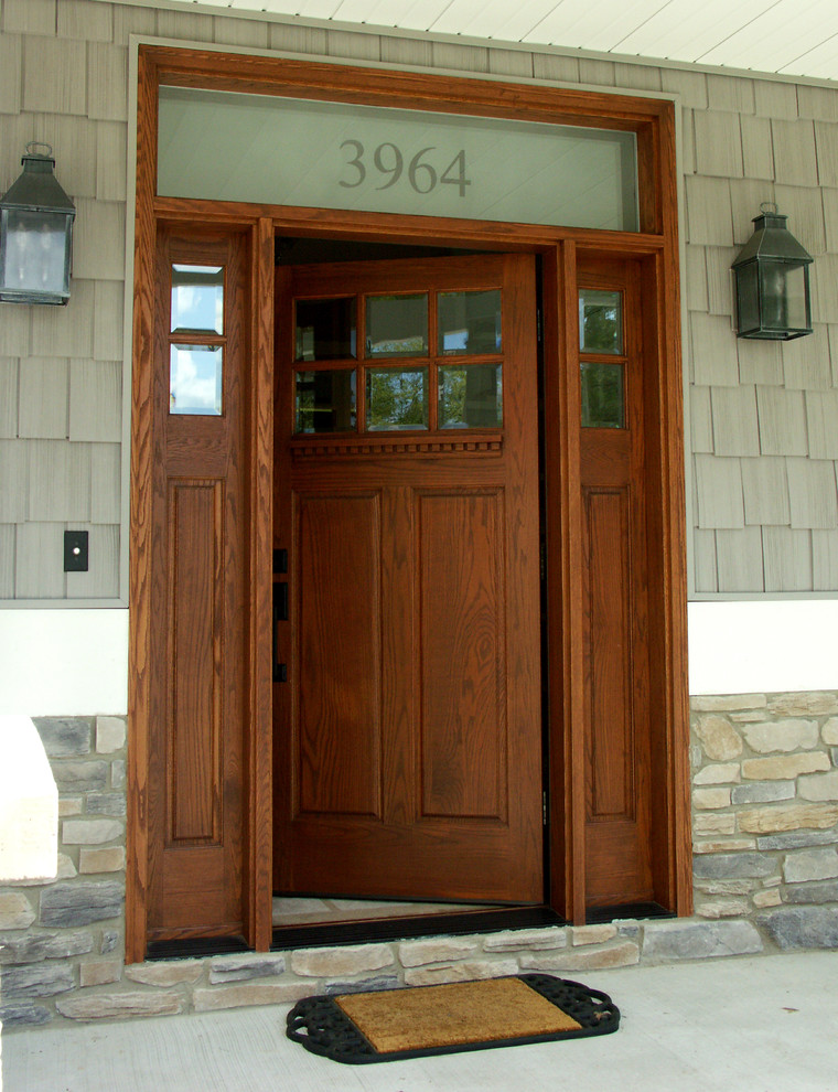 Esempio di una porta d'ingresso american style di medie dimensioni con pavimento in legno massello medio, una porta singola e una porta in legno scuro