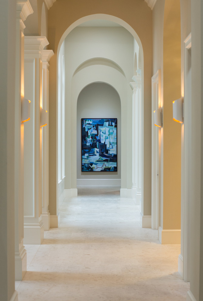 Großer Klassischer Eingang mit Korridor, beiger Wandfarbe, Kalkstein, Einzeltür, hellbrauner Holzhaustür und beigem Boden in Tampa