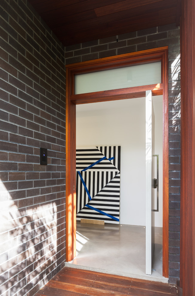 Design ideas for a contemporary front door in Sydney with white walls, concrete flooring, a pivot front door and a white front door.