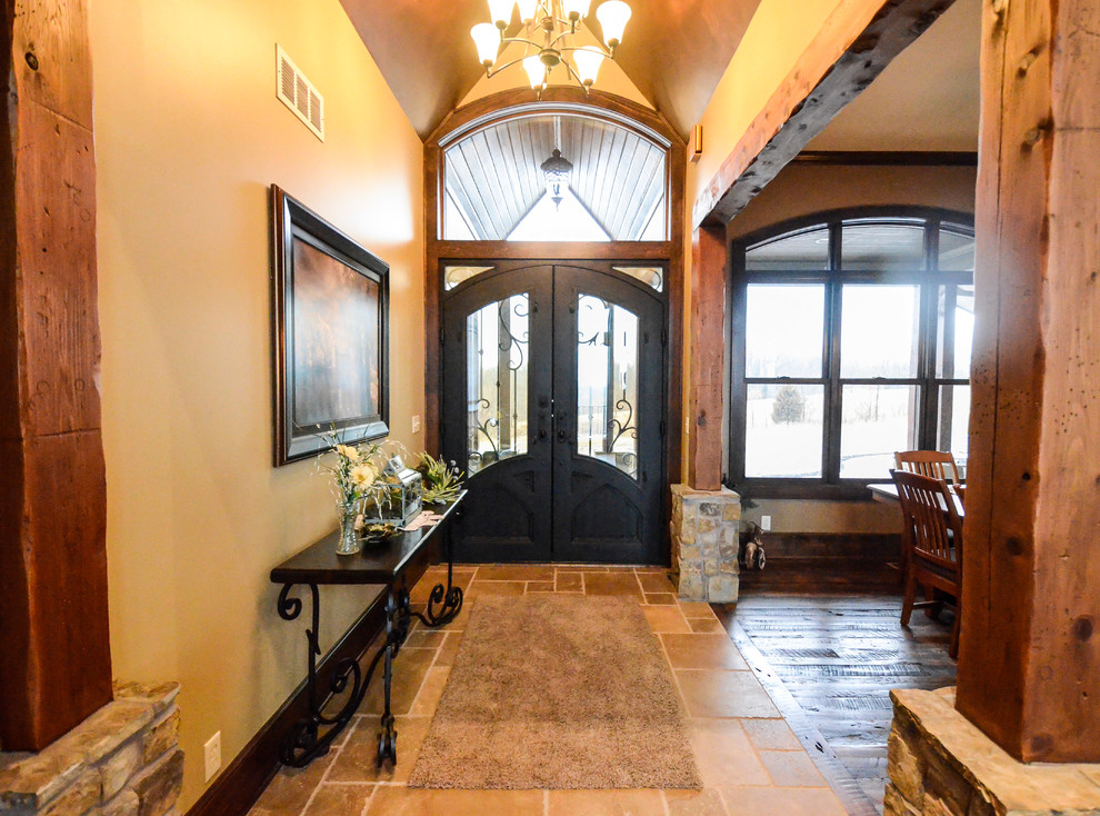 Inspiration for a large rustic ceramic tile entryway remodel in Kansas City with beige walls and a brown front door