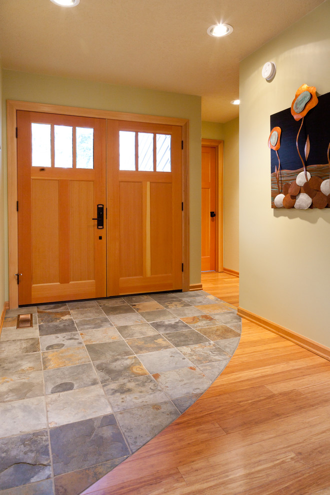 Inspiration pour un hall d'entrée design de taille moyenne avec un mur vert, un sol en ardoise, une porte double et une porte en bois brun.