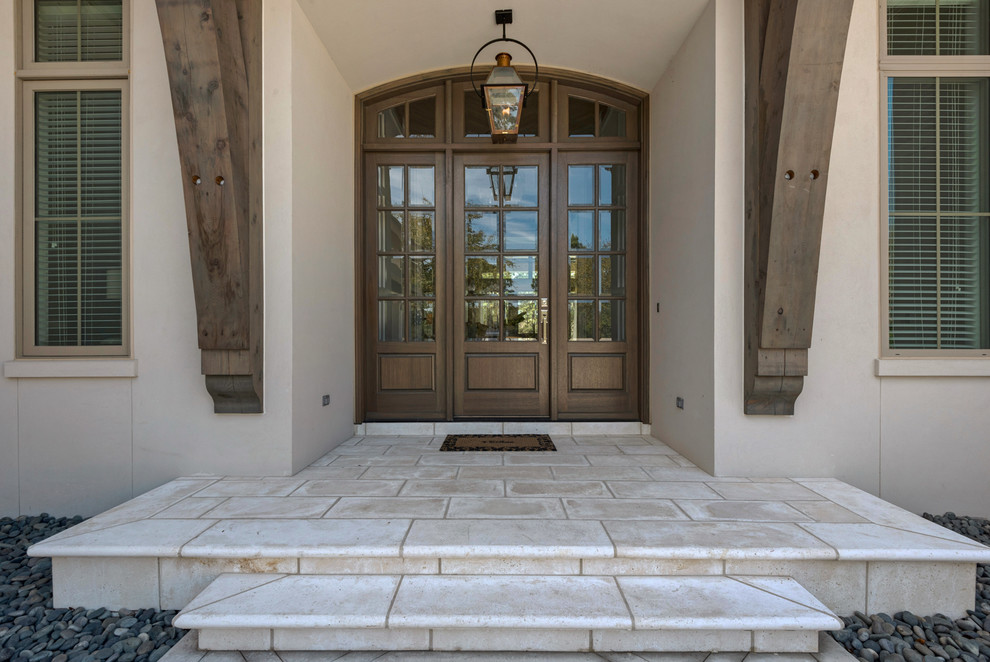 На фото: большая входная дверь в морском стиле с бежевыми стенами, одностворчатой входной дверью и входной дверью из дерева среднего тона с