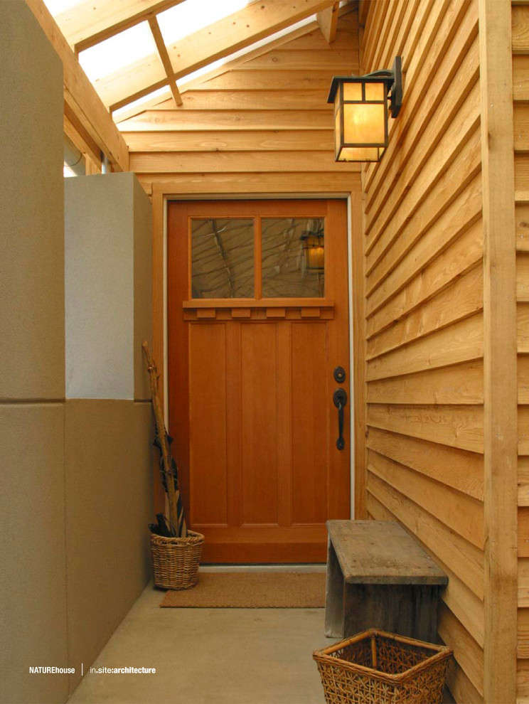 Réalisation d'une entrée design de taille moyenne avec sol en béton ciré, une porte simple et une porte en bois brun.