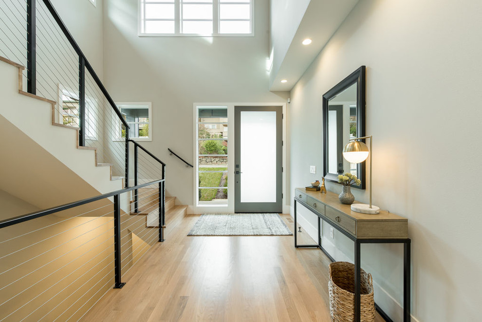 Entryway - mid-sized contemporary light wood floor and beige floor entryway idea in Seattle with gray walls and a glass front door