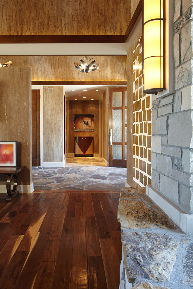 Aménagement d'un grand hall d'entrée craftsman avec un mur marron, un sol en bois brun, une porte double et une porte en bois brun.