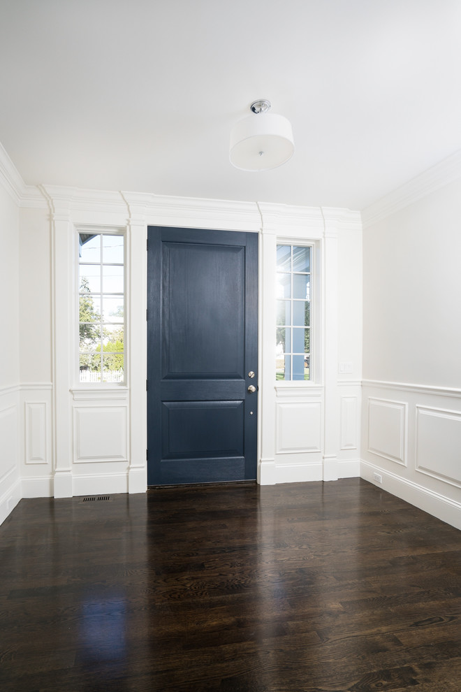 Exemple d'une grande porte d'entrée chic avec un mur gris, parquet foncé, une porte simple, une porte bleue et un sol marron.