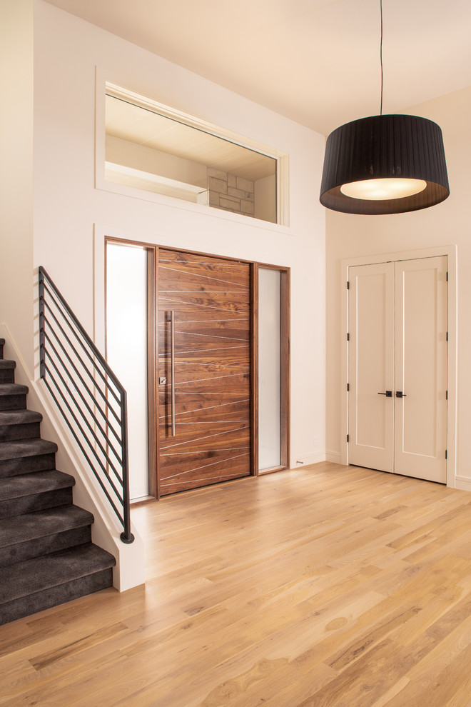 Ispirazione per un grande ingresso moderno con pareti bianche, parquet chiaro, una porta singola, una porta in legno bruno e pavimento beige
