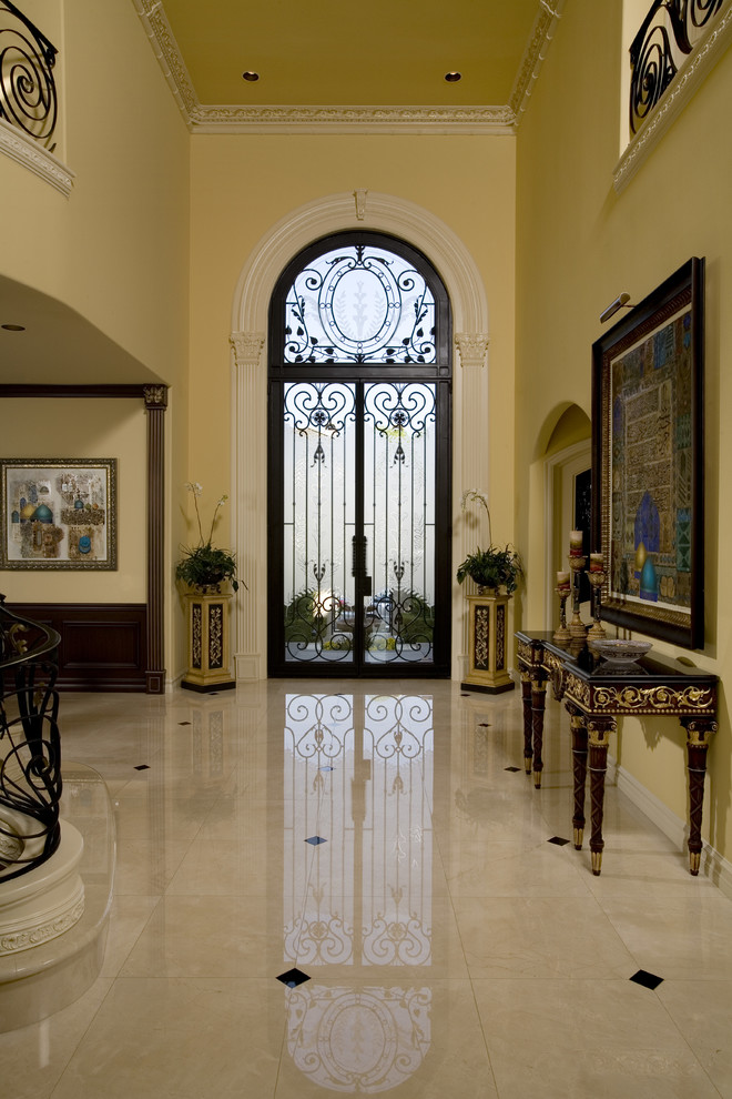 Photo of an expansive classic foyer in Orange County with yellow walls, ceramic flooring, a double front door and a glass front door.