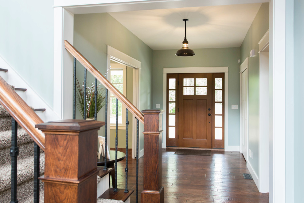 Idee per una porta d'ingresso american style di medie dimensioni con pareti verdi, pavimento in legno massello medio, una porta singola, una porta in legno bruno e pavimento marrone