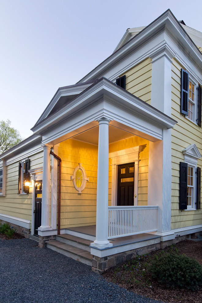Источник вдохновения для домашнего уюта: входная дверь в классическом стиле с желтыми стенами, деревянным полом, одностворчатой входной дверью, черной входной дверью и серым полом