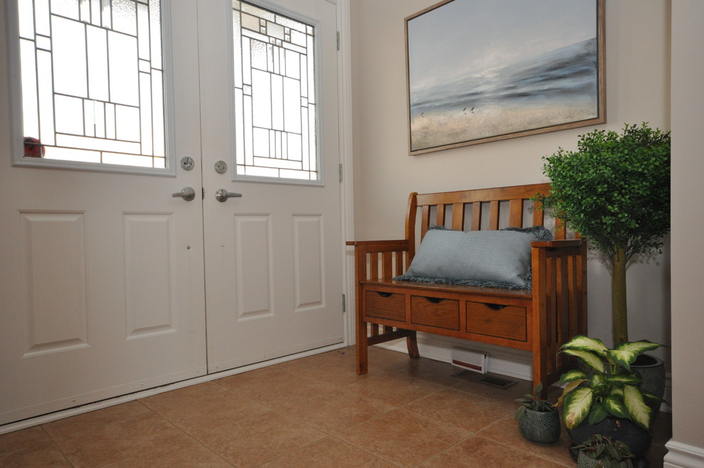 На фото: прихожая в классическом стиле с бежевыми стенами, полом из керамогранита, двустворчатой входной дверью, белой входной дверью и оранжевым полом