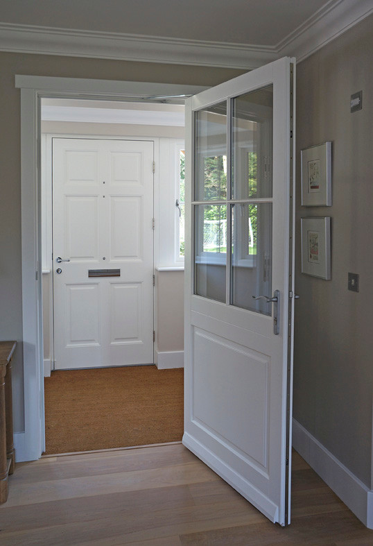 Foto de entrada actual con puerta simple y puerta de madera clara