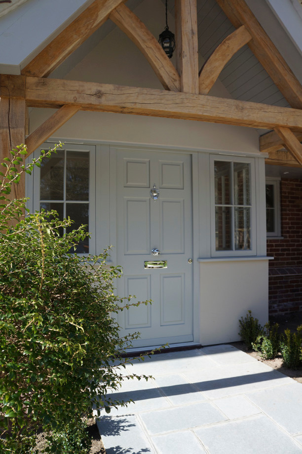 Diseño de entrada actual con puerta simple y puerta de madera clara