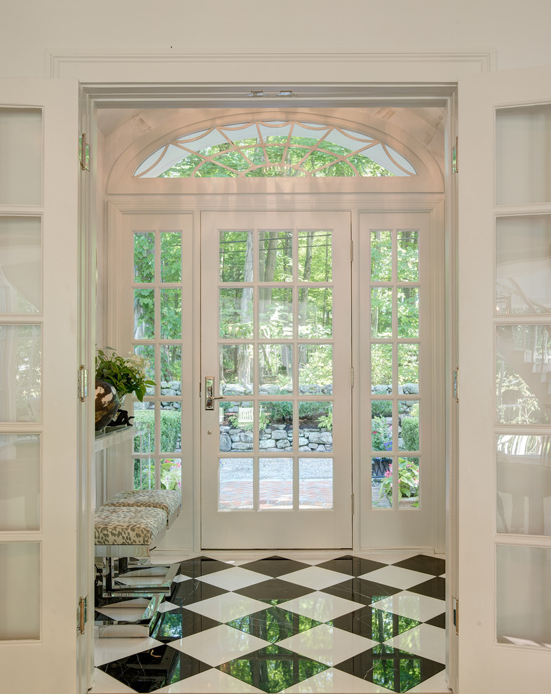 Réalisation d'une porte d'entrée tradition de taille moyenne avec un mur blanc, un sol en marbre, une porte simple et une porte blanche.