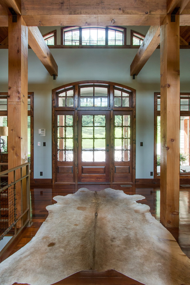 Ejemplo de puerta principal rural de tamaño medio con paredes blancas, suelo de madera en tonos medios, puerta simple, puerta de vidrio y suelo marrón