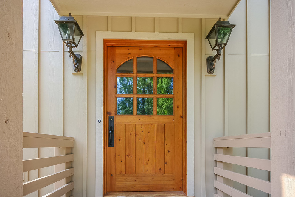 На фото: входная дверь среднего размера в стиле кантри с бежевыми стенами, деревянным полом, одностворчатой входной дверью и входной дверью из дерева среднего тона с