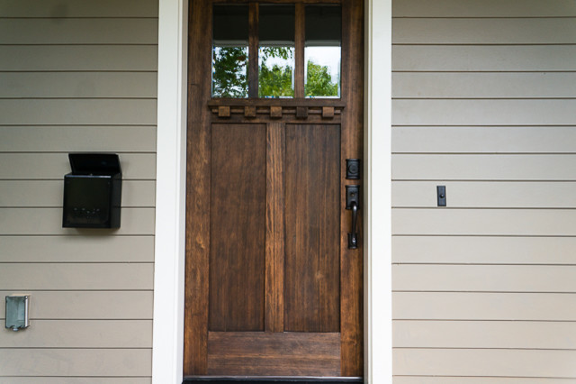 Exemple d'une porte d'entrée craftsman de taille moyenne avec un mur marron, une porte simple et une porte en bois brun.