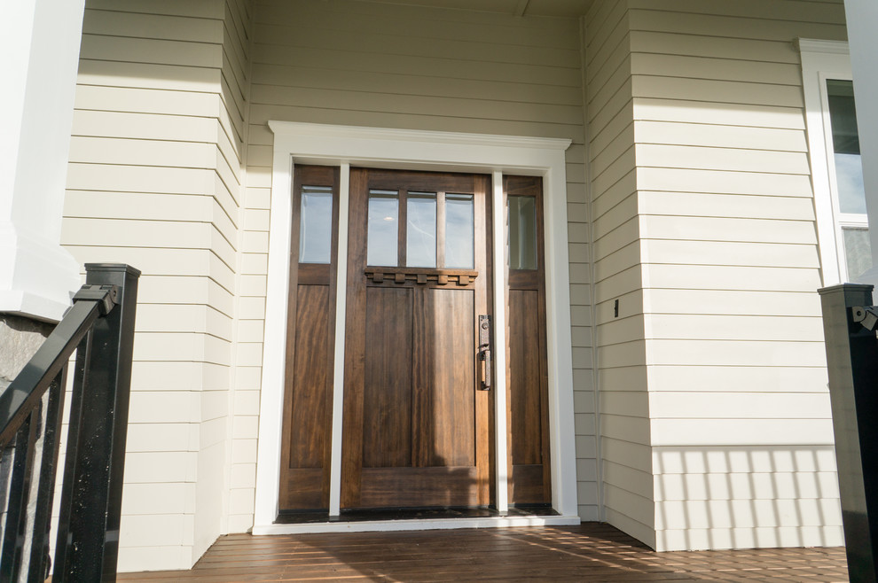 Modelo de puerta principal tradicional de tamaño medio con paredes beige, suelo de madera en tonos medios, puerta simple y puerta de madera oscura