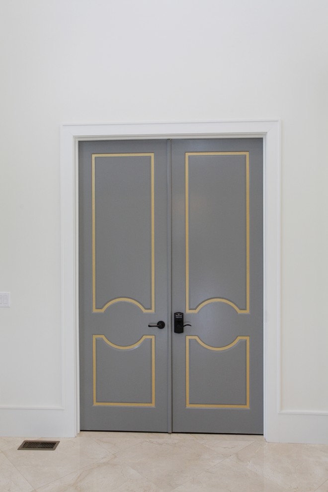 Ispirazione per un ampio corridoio minimal con pareti bianche, pavimento in marmo, una porta a due ante, una porta in metallo e pavimento beige