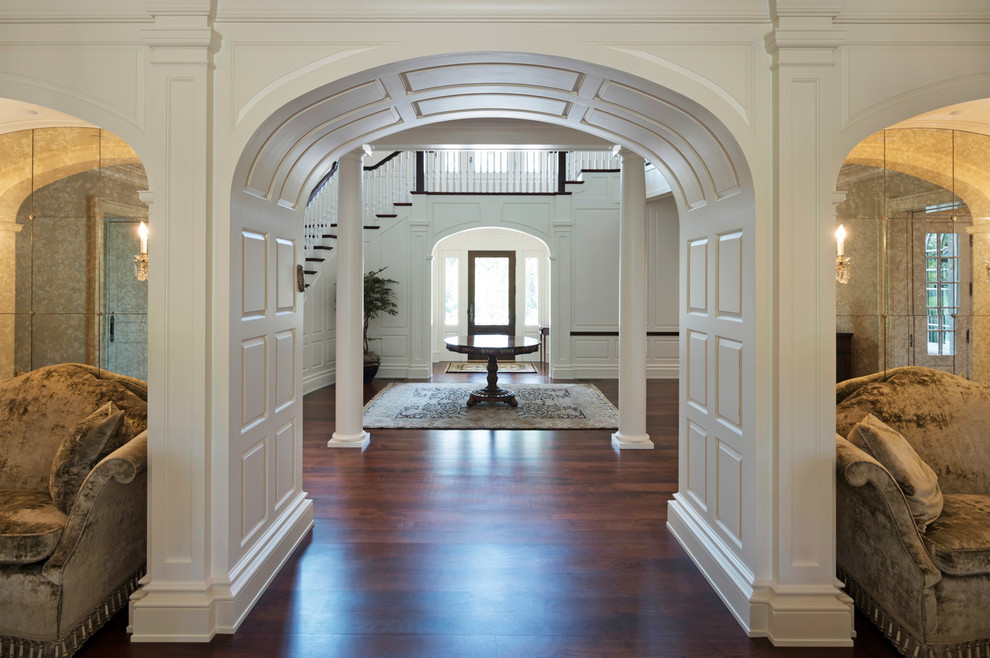 Foto de puerta principal clásica de tamaño medio con paredes blancas, suelo de madera oscura, puerta simple, puerta blanca y suelo marrón