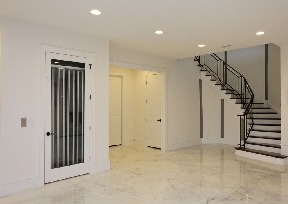 Imagen de sótano con puerta contemporáneo grande con paredes blancas, suelo de mármol y suelo blanco