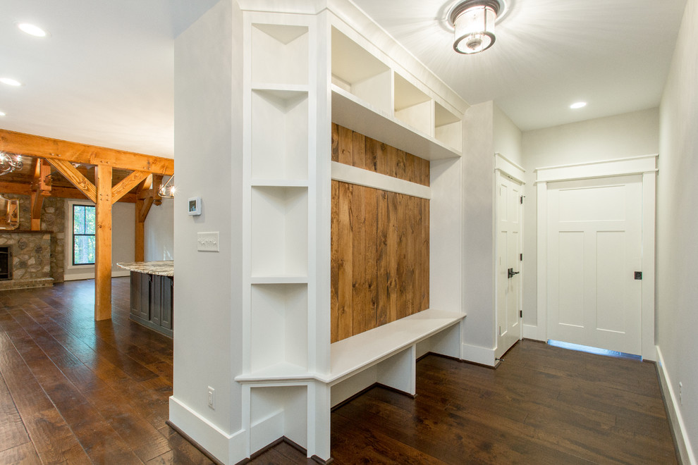 Exemple d'une entrée craftsman de taille moyenne avec un vestiaire, un mur gris, parquet foncé, une porte simple, une porte blanche et un sol marron.