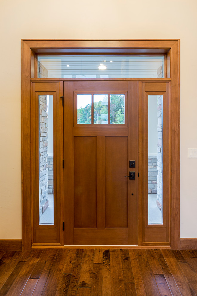 Ejemplo de puerta principal de estilo americano de tamaño medio con paredes marrones, suelo de cemento, puerta simple y puerta de madera oscura