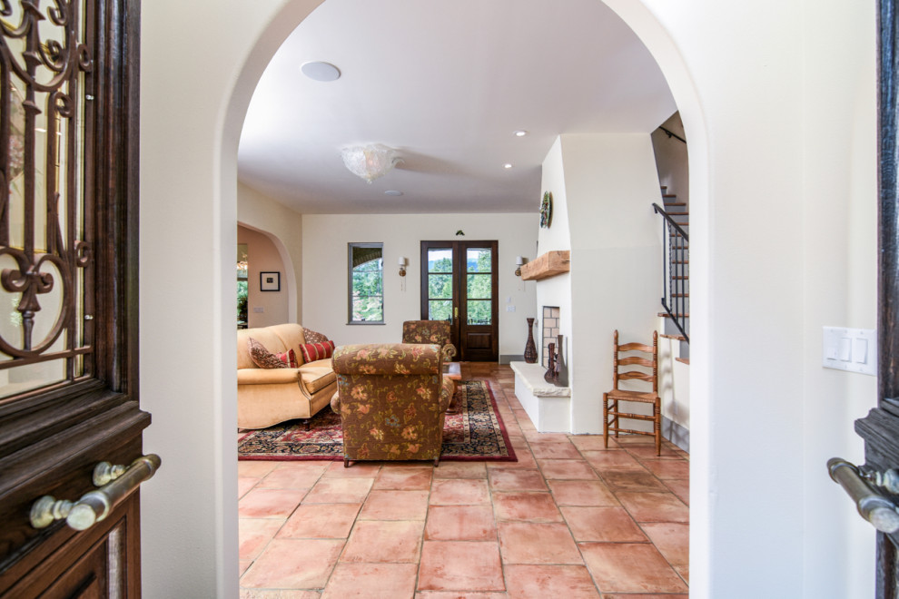 Kleines Mediterranes Foyer mit weißer Wandfarbe, Terrakottaboden, Doppeltür, brauner Haustür und buntem Boden in Sonstige