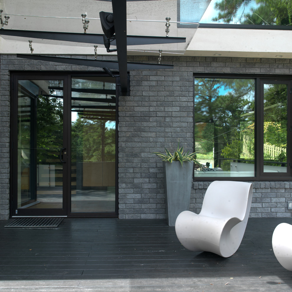 Diseño de entrada abovedada y blanca contemporánea grande con puerta de vidrio, paredes grises, suelo de madera oscura, puerta simple, suelo negro y ladrillo