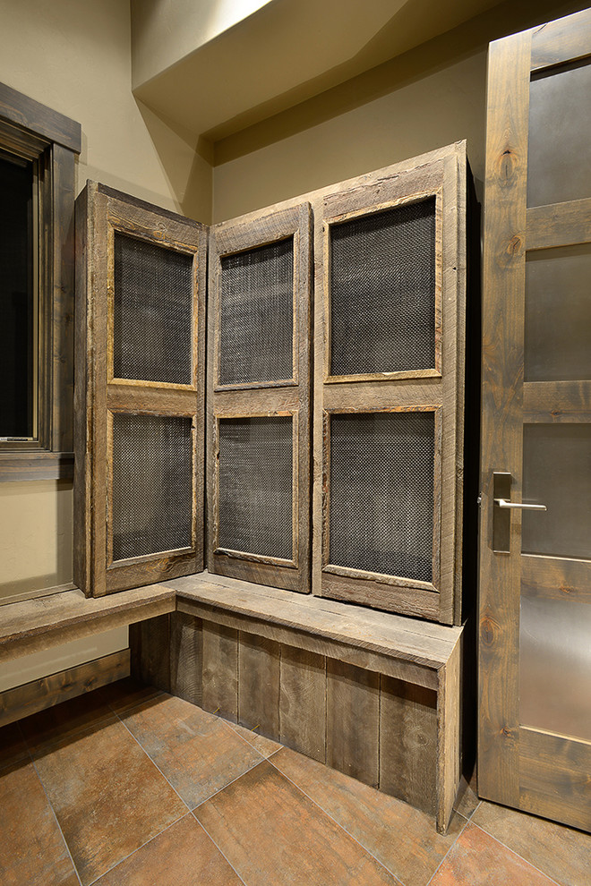 Ejemplo de distribuidor rústico de tamaño medio con paredes beige, suelo de pizarra, puerta simple, puerta de madera en tonos medios y suelo multicolor