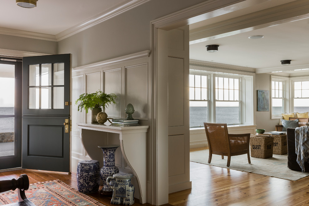 Maritimer Eingang mit Korridor, grauer Wandfarbe, braunem Holzboden, Klöntür und schwarzer Haustür in Boston