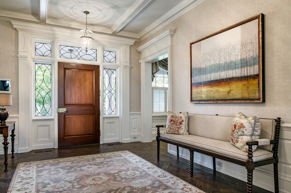 Photo of a traditional entrance in New York with beige walls, medium hardwood flooring, a single front door, a medium wood front door and feature lighting.