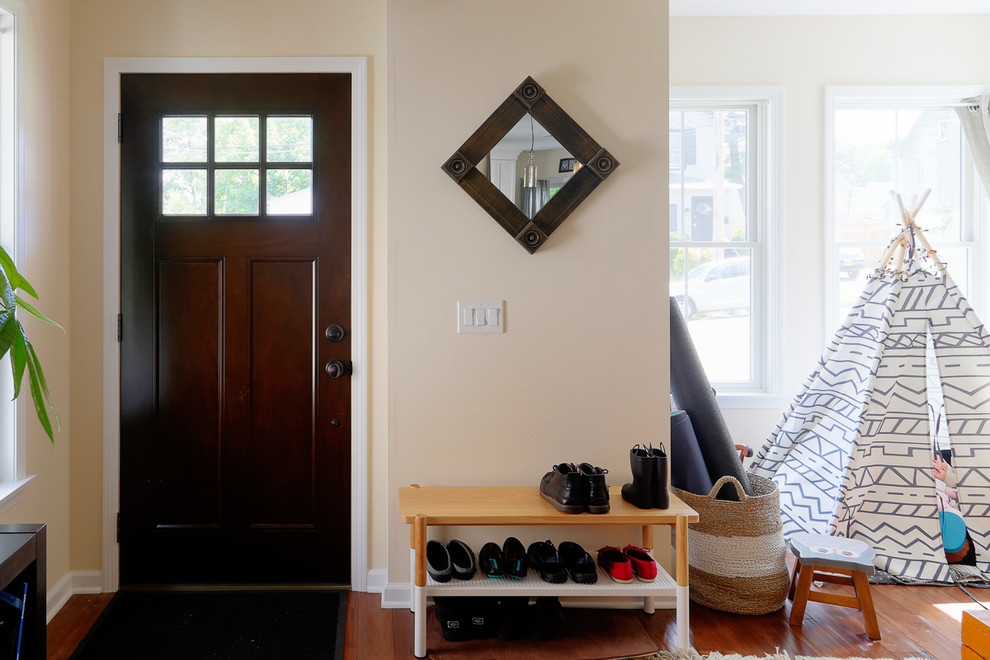На фото: входная дверь среднего размера в стиле неоклассика (современная классика) с бежевыми стенами, паркетным полом среднего тона, одностворчатой входной дверью, входной дверью из темного дерева и коричневым полом с
