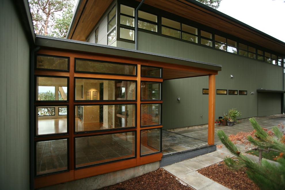 На фото: входная дверь среднего размера с белыми стенами, полом из сланца, одностворчатой входной дверью, входной дверью из дерева среднего тона и коричневым полом