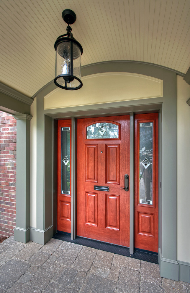 Cette image montre une porte d'entrée traditionnelle de taille moyenne avec un mur vert, une porte simple et une porte en bois brun.