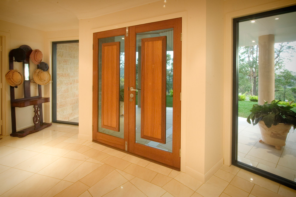 Immagine di un'ampia porta d'ingresso minimalista con pareti beige, pavimento in marmo, una porta a due ante e una porta in legno bruno
