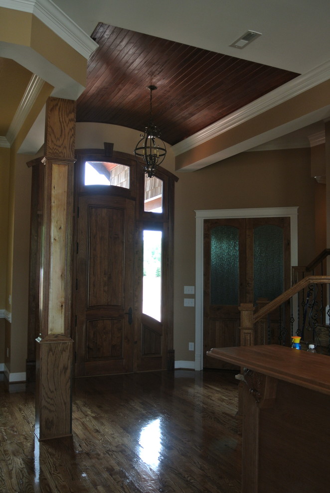 Photo of a large rustic foyer in Charleston with beige walls, medium hardwood flooring, a single front door and a dark wood front door.