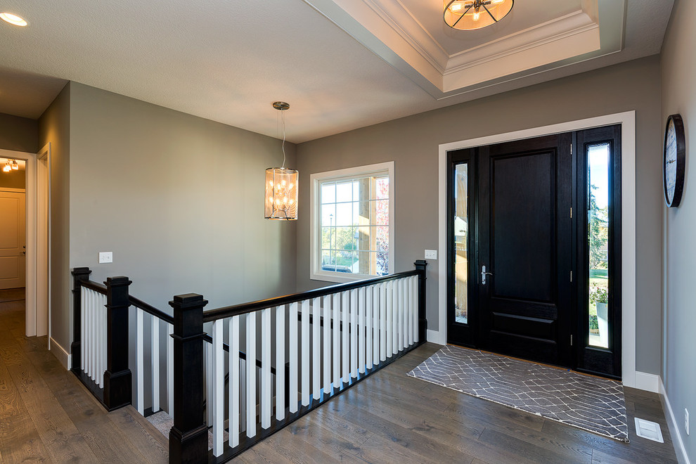 Свежая идея для дизайна: входная дверь среднего размера в стиле неоклассика (современная классика) с серыми стенами, темным паркетным полом, одностворчатой входной дверью, черной входной дверью и коричневым полом - отличное фото интерьера