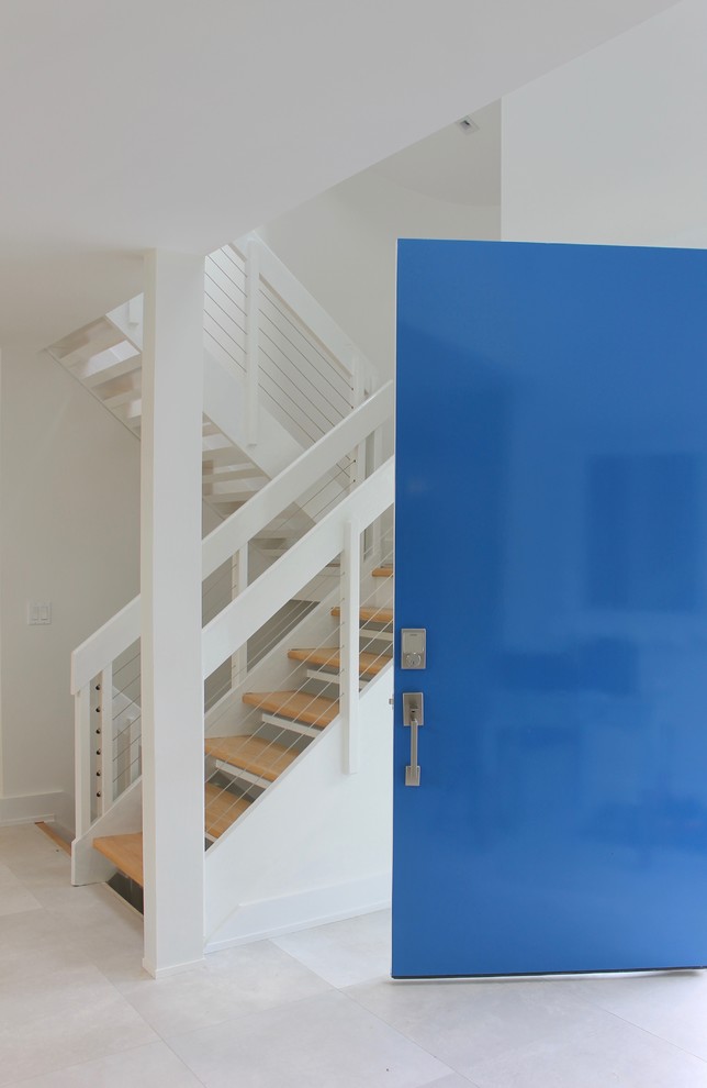 Ejemplo de puerta principal minimalista extra grande con paredes blancas, suelo de baldosas de porcelana, puerta simple y puerta azul