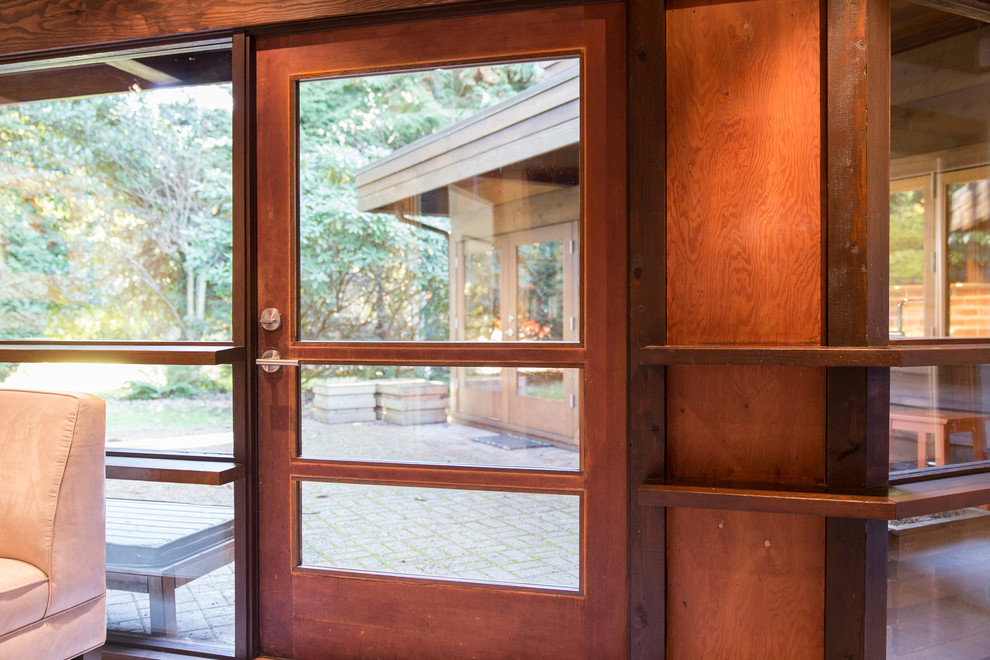 На фото: входная дверь среднего размера в стиле ретро с бетонным полом, одностворчатой входной дверью, входной дверью из дерева среднего тона и серым полом