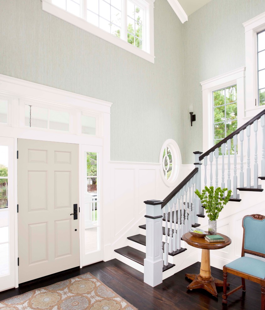 Cette photo montre un grand hall d'entrée chic avec un mur vert, parquet foncé, une porte simple et une porte grise.