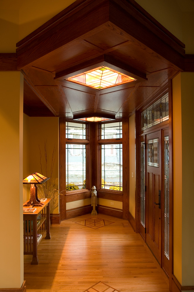 Example of an asian light wood floor entryway design in Chicago with a medium wood front door