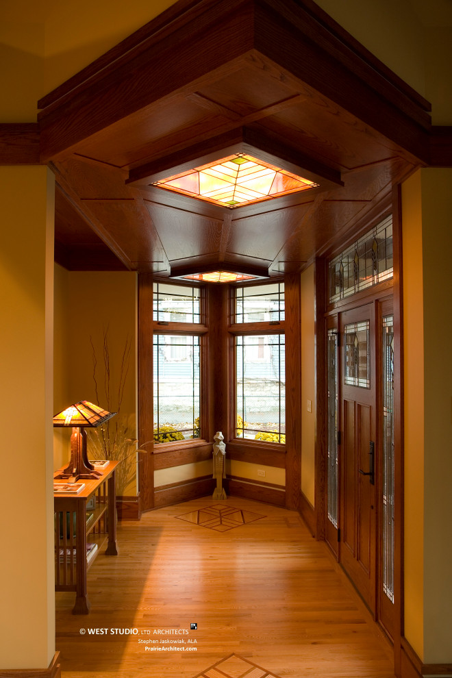 На фото: фойе среднего размера в восточном стиле с светлым паркетным полом, одностворчатой входной дверью, входной дверью из дерева среднего тона и разноцветным полом с