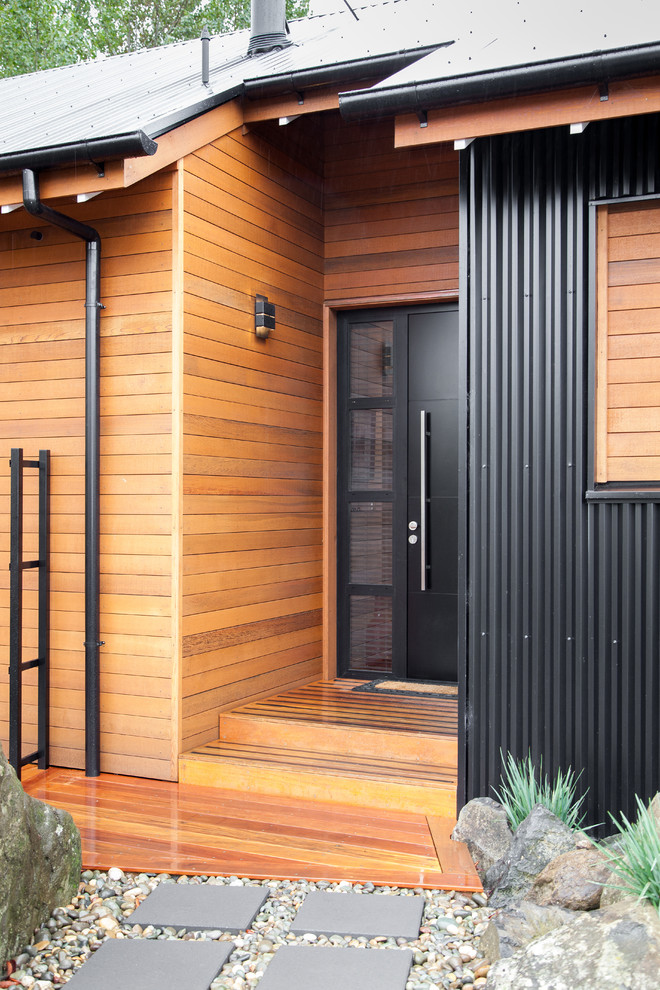 Cette image montre une petite porte d'entrée design avec un mur multicolore, une porte simple et une porte noire.
