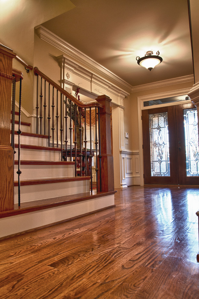 Example of a mid-sized classic medium tone wood floor entryway design in Atlanta with black walls and a dark wood front door