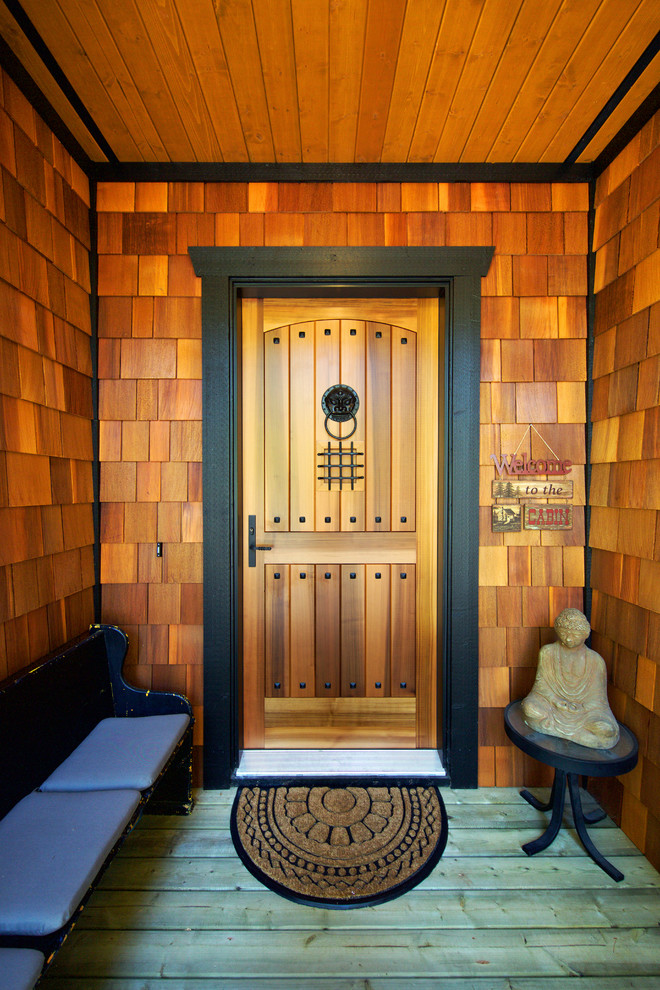 На фото: входная дверь среднего размера в стиле рустика с поворотной входной дверью и входной дверью из дерева среднего тона
