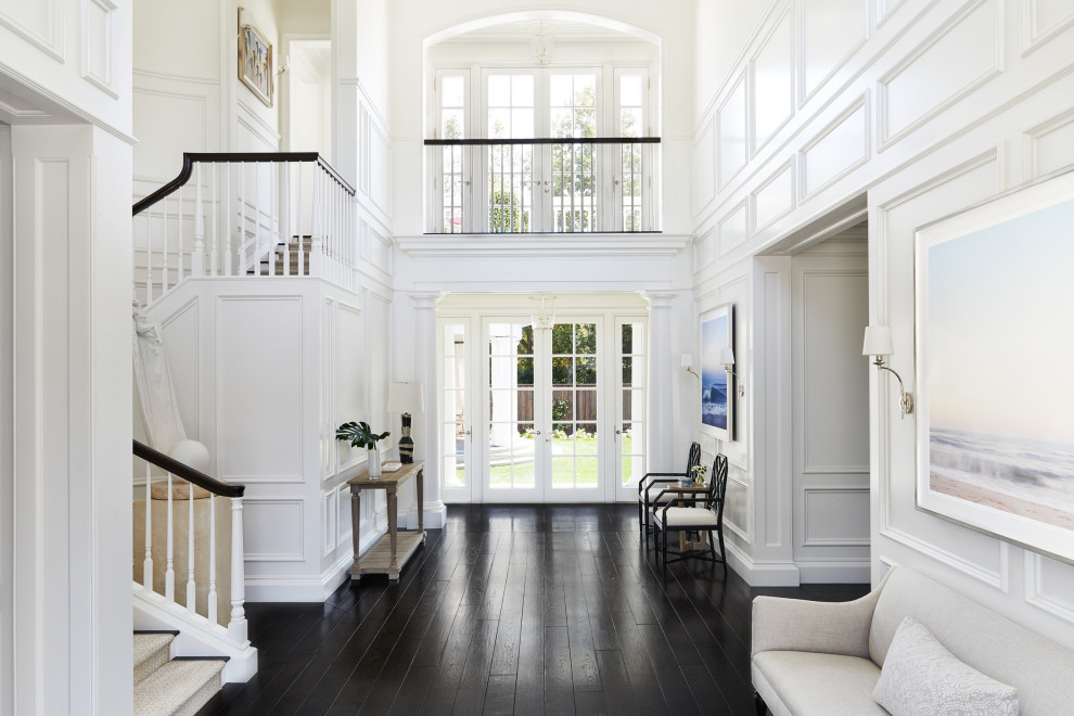 Photo of a large traditional foyer in San Francisco with white walls, dark hardwood flooring and brown floors.