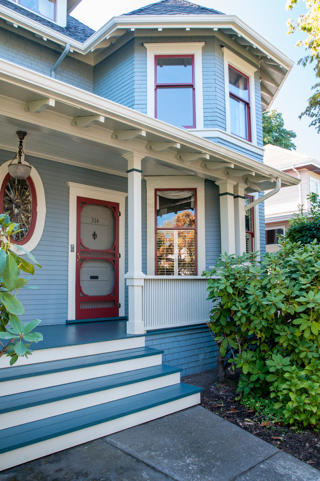 Klassische Haustür mit blauer Wandfarbe, gebeiztem Holzboden und Einzeltür in Vancouver