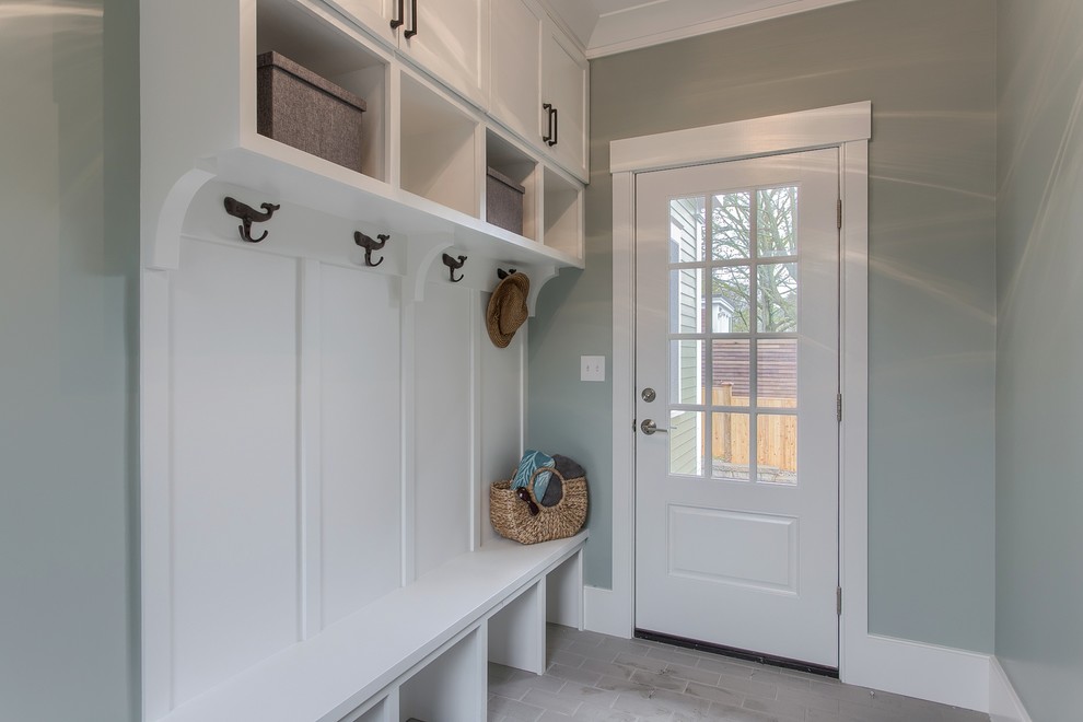 Inredning av ett lantligt mellanstort kapprum, med grå väggar, ljust trägolv, en enkeldörr, beiget golv och en vit dörr